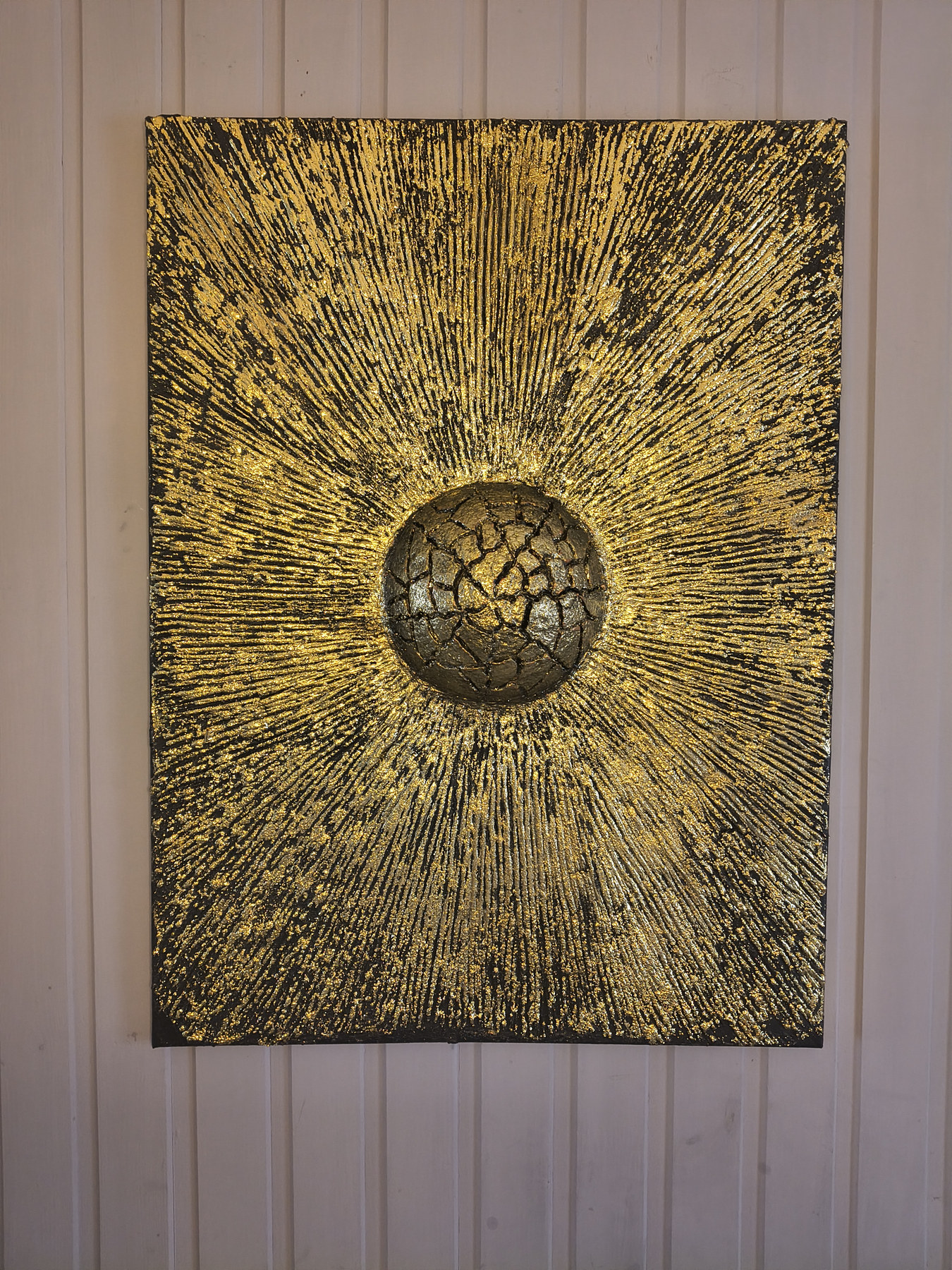 Black-and-gold textured artwork with a cracked circular centre and fine lines radiating across the surface, by Dan'Art.
